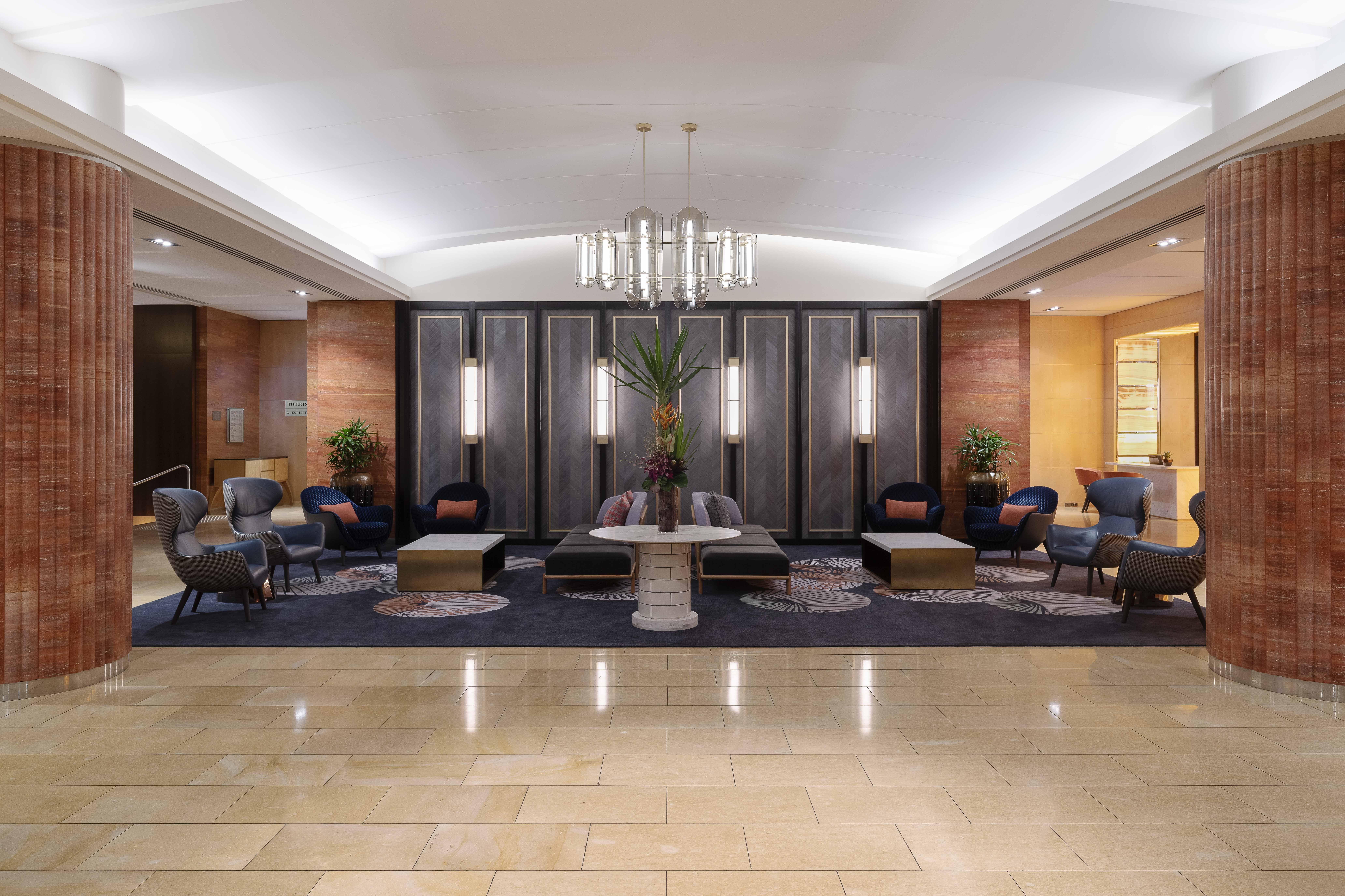 Amora Hotel Jamison Sydney Ngoại thất bức ảnh The photo depicts a modern hotel lobby featuring a sophisticated and welcoming ambiance. The space includes various seating arrangements with a mix of chairs and couches, positioned around a central coffee table. The decor is elegant, with a combinat