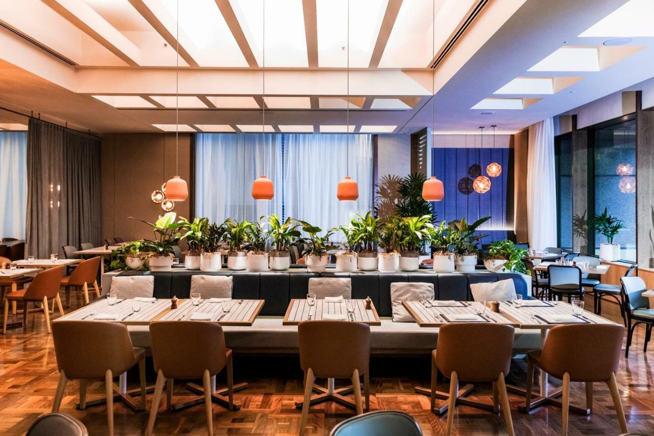 Amora Hotel Jamison Sydney Ngoại thất bức ảnh The photo shows the interior of a modern restaurant. It features a spacious dining area with a variety of seating options, including wooden chairs and benches. The tables are set with simple tableware, creating an inviting atmosphere. 

The decor inc